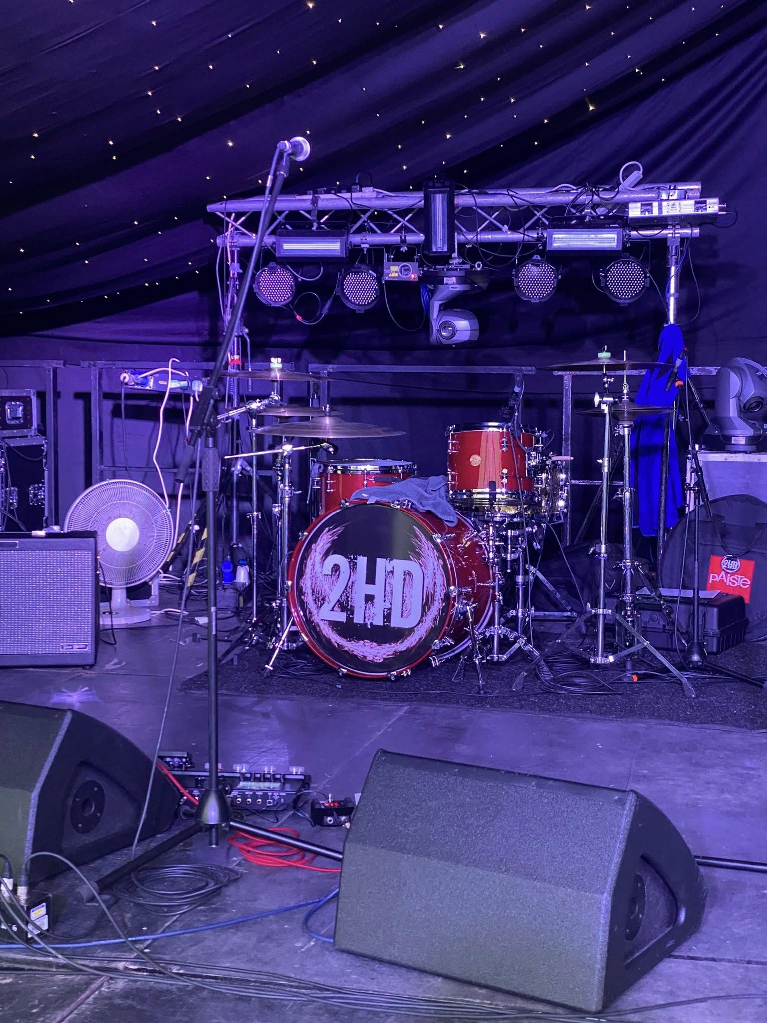 2HD branded drum kit under purple stage lighting